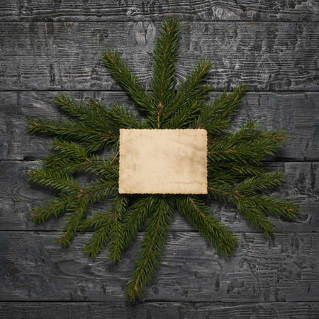 Spruce branches with a sheet of old paper on a wooden table. Space for your text. A letter requesting a gift.の写真素材
