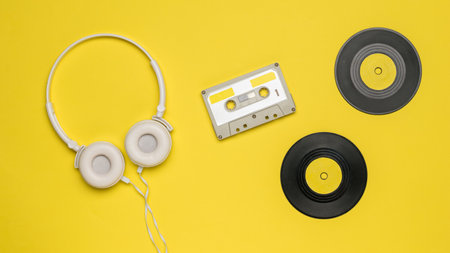 Tape cassette, headphones and vinyl records on a yellow background.の写真素材
