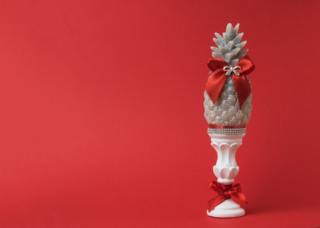 Decorative candle on a stand with red ribbons on a red background. Beautiful scenery.の写真素材