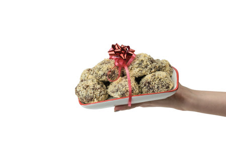 Hand with a bowl of homemade sweets isolated on a white background. Delicious fresh home-made candies.の写真素材