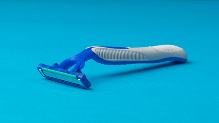 Blue and gray disposable razor on a blue background. Tools for facial care.の写真素材