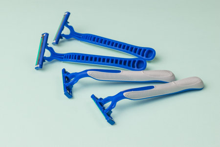 Disposable razors scattered on the table on a blue background. Tools for facial care. Set for care of a man's face.の写真素材