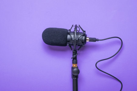 Microphone with a cord screwed to the stand on a purple background. Sound recording equipment.の写真素材