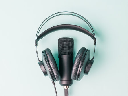 Modern headphones and microphone on a blue background. Equipment for recording and reproducing sound.の写真素材