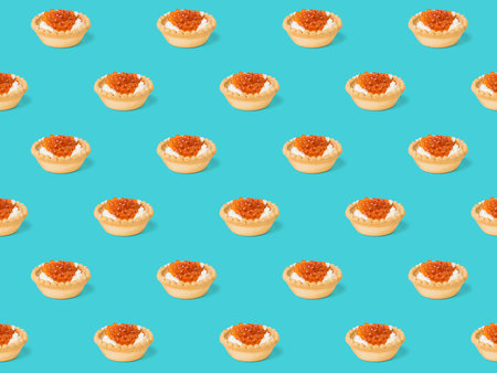 Seamless pattern of tartlets with cream cheese and caviar on a blue background. Appetizer with sea delicacies.の写真素材