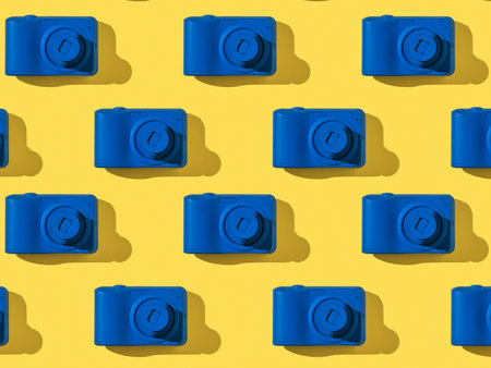 A pattern of stylish blue cameras on a yellow background. Equipment for photography.の写真素材
