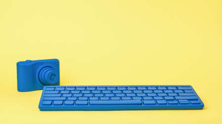 A bright blue keyboard and a bright blue camera on a yellow background. Stylish accessories for...