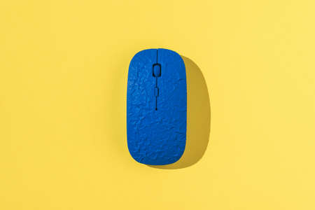 A stylish blue computer mouse on a bright yellow background. Computer accessories.の写真素材