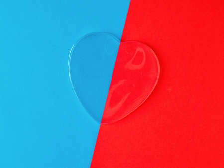 Transparent heart on a blue and red background. A symbol of love and life.