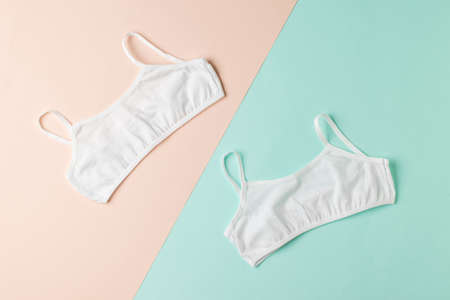 Two simple white bras on a two-tone background. Underwear for girls.の写真素材
