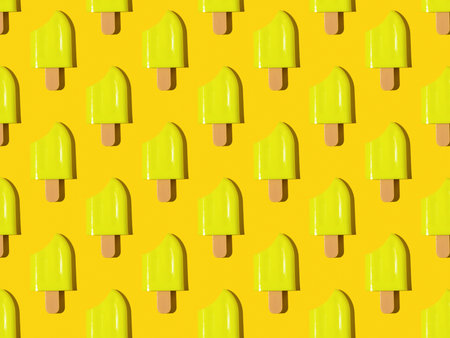 A pattern of yellow bitten on a yellow background. A popular summer snack.の写真素材