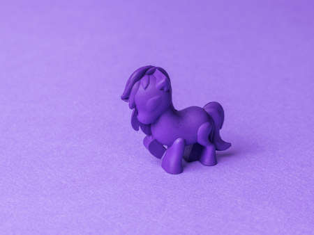 Figure of a purple pony on a purple background. Monochrome image of a fashionable toy.