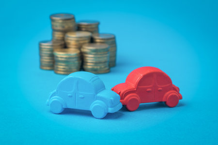 Installation of the accident of two cars on the background of yellow coins. A traffic accident.の写真素材