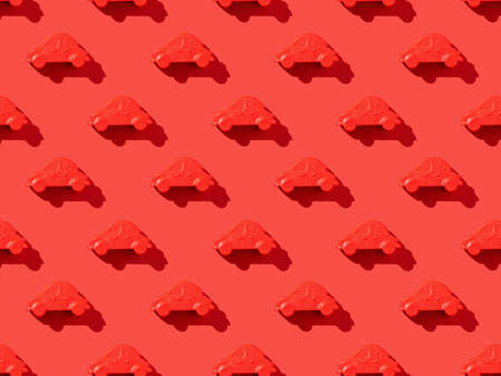 A pattern of red cars on a bright red background. The concept of selling and buying cars.の写真素材