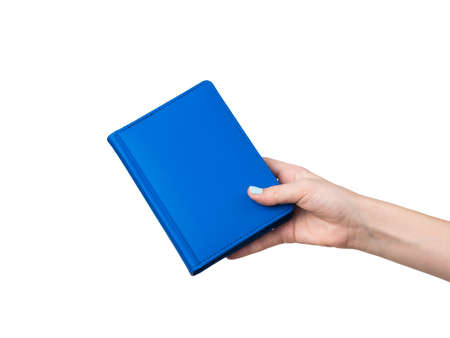 A woman's hand with a blue notebook isolated on a white background. Stylish office supplies.