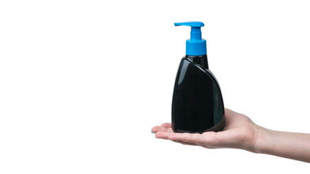 A woman's hand with a black bottle filled with liquid soap isolated on a white background. Detergent...