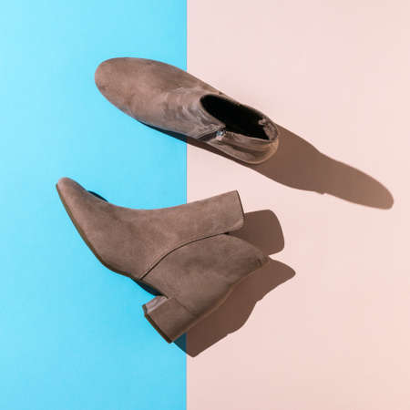 Women's light boots in hard light on blue and beige background. Stylish demi-season women's shoes.の写真素材