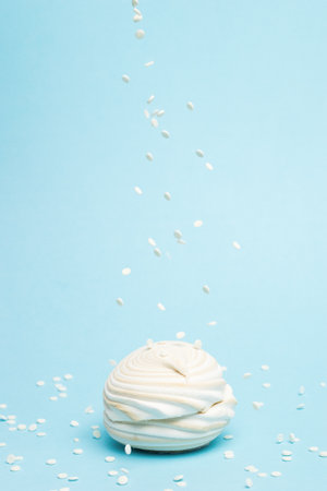 Light confit drips on fresh meringue on a blue background. Delicious sweetness of eggs and sugar.の写真素材