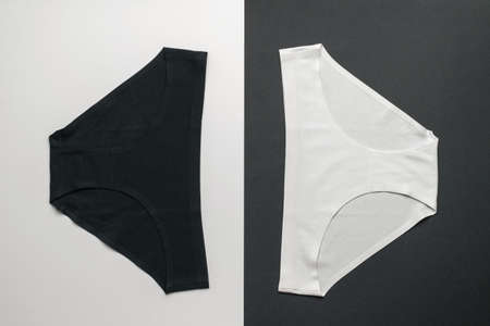 Classic women's black and white panties on a white and black background. Lingerie. Flat lay.