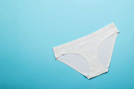 White cotton women's panties on a light blue background. Lingerie. Flat lay.の写真素材