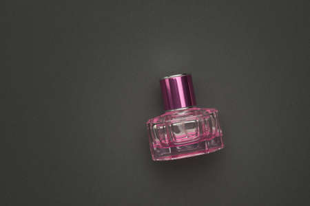 A red perfume bottle on a dark gray background. Aromatic liquid.の写真素材