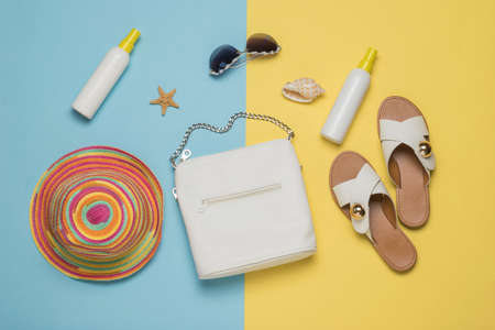 Women's accessories for relaxing by the sea on a yellow and blue background. Vacation concept. Flat lay.の写真素材
