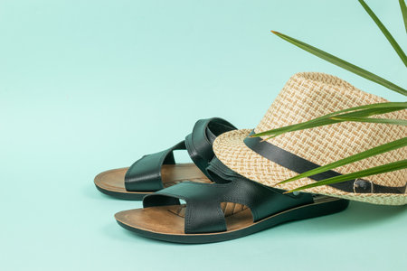 Men's summer hat on black sandals on a blue background. Summer men's shoes.の写真素材