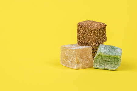 Three types of Turkish delight on a yellow background. Oriental sweets.の写真素材