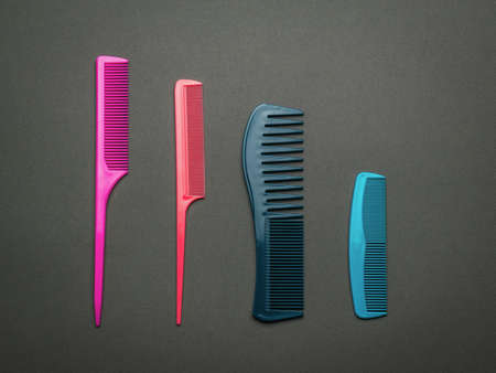Four plastic combs on a dark gray background. A tool for hair care. Flat lay.の写真素材