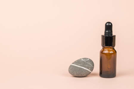 A beautiful blue stone and a bottle with an eyedropper on a beige background. The concept of treatment and body care using natural remedies.の写真素材