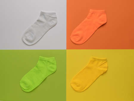Four multi-colored socks on a four-color background. A stylish sports accessory.