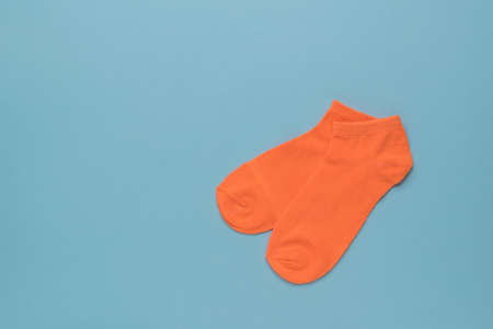 A pair of orange sports socks on a blue background. A stylish sports accessory. Flat lay.の写真素材