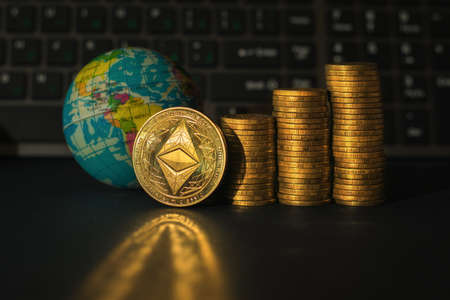 The ethereum coin against the background of stacks of coins and a financial chart. Digital currency.