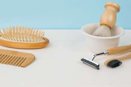Shaving accessories, a toothbrush and combs on a white table on a blue background. Men's accessories...