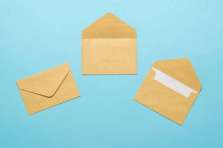 Three postal envelopes on a light blue background. The concept of mail correspondence. Flat lay.