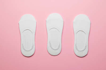 Three pairs of packed women's white short socks on a pink background. A stylish sports accessory.の写真素材