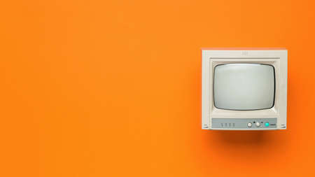 Vintage TV on an orange background. Space for the text. Retro equipment. Flat lay.の写真素材