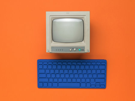 Vintage monitor and blue keyboard on an orange background. Retro equipment. Flat lay.