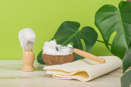 The process of shaving with vintage tools on a background of green leaves. Men's accessories for appearance care.の写真素材