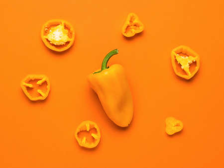 Whole and cut yellow bell pepper on a green background. Vegetarian food. A fresh crop of vegetables.の写真素材