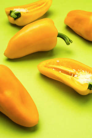 Ripe yellow bell pepper scattered on a green background. Vegetarian food. A fresh crop of...