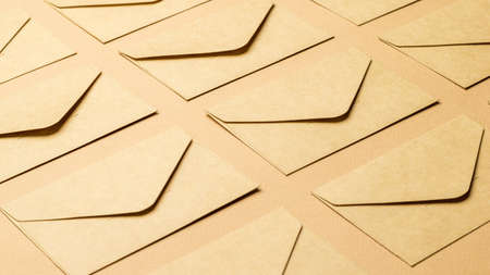Background of closed paper envelopes on a paper background. The concept of mail correspondence.の写真素材