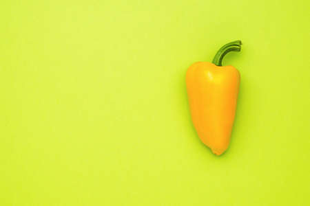 Ripe yellow pepper on a light green background. Vegetarian food. A fresh crop of vegetables.