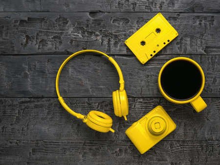 Headphones, coffee, a camera and a cassette on a wooden table. Creative breakfast.の写真素材