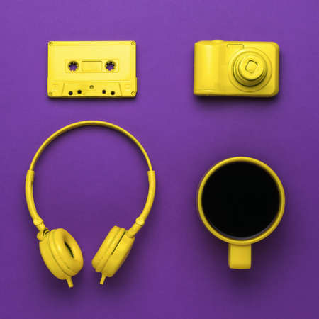 Vintage image of a coffee cup and stylish yellow accessories on a purple background. Color trend. Stylish accessories.の写真素材