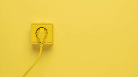 A yellow electrical cord from an electrical appliance connected to a yellow outlet. Stylish design. The place where electrical appliances are connected.の写真素材