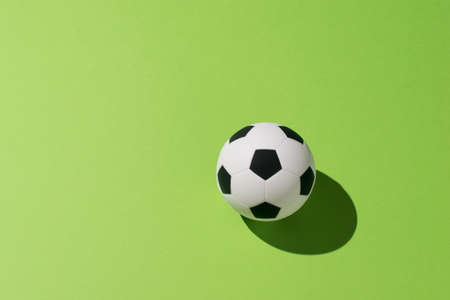 Soccer ball on a green background in bright light. The concept of the popular ball game.の写真素材