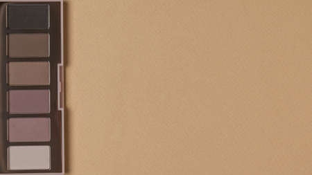 Top view of a set of eye shadow in pastel colors on a beige background. Stylish women's cosmetics. Space for text.の写真素材