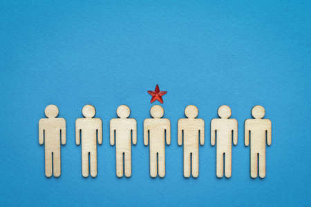 A row of wooden men and one leader marked with a star. The concept of the head. Business idea.の写真素材