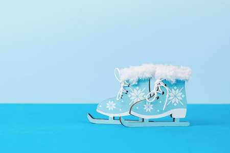 Beautiful blue ice skating toys on a two-tone blue background. Winter sports and entertainment.の写真素材